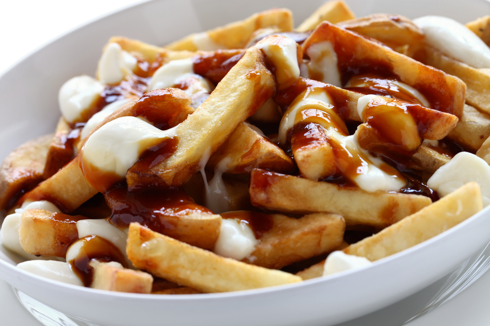 Close-up of a bowl of poutine with fries, gravy and cheese curds.