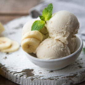 Bowl of banana ice cream with banana slices and mint.