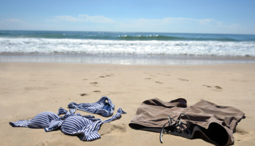 A man and woman's bathing suits on a beach.
