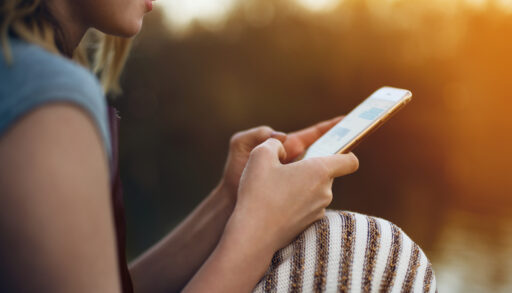 Close-up of a young woman scrolling through her smartphone.