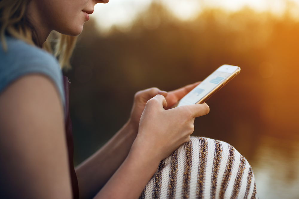 Close-up of a young woman scrolling through her smartphone.