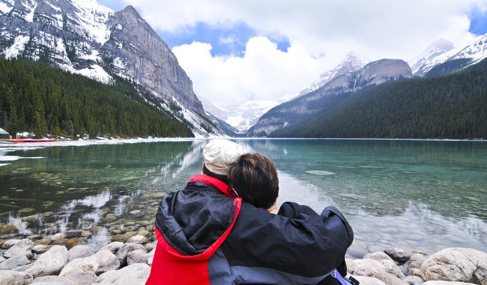 A couple sitting by Lake Louise in Banff, Canada.