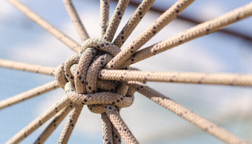 Close-up of a knot created by a web of ropes.