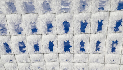 Close-up of rime ice on a metal fence.