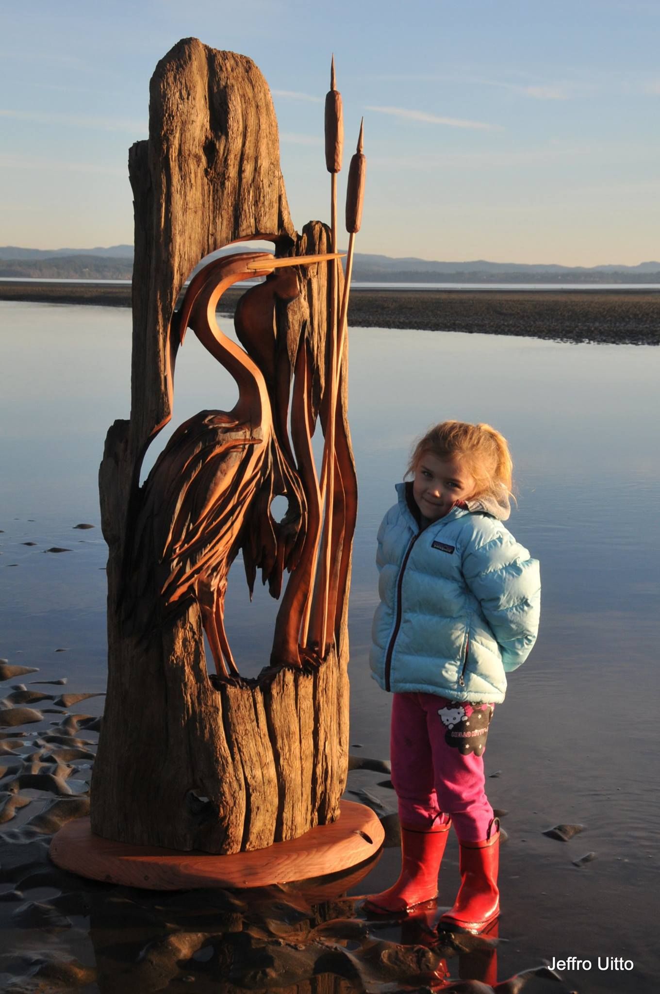 Jeffro's daughter, Timber, stands next to a sculpture of a heron.