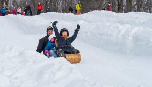Man and children on a sled going down a hill