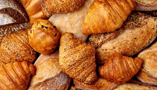 Overhead view of different croissants and types of bread.