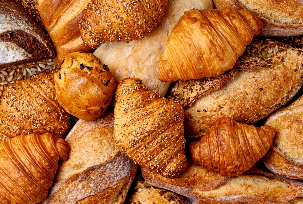 Overhead view of different croissants and types of bread.