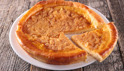 Close-up of a sugar tart on a white plate.