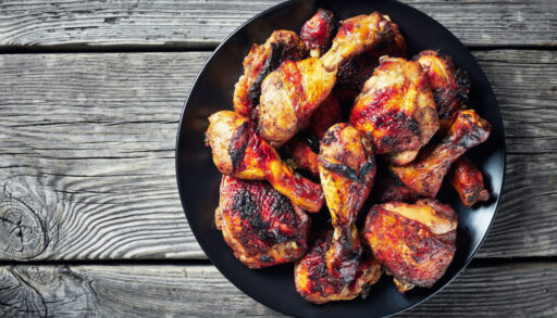 Flat lay of cooked jerk chicken in a black bowl.