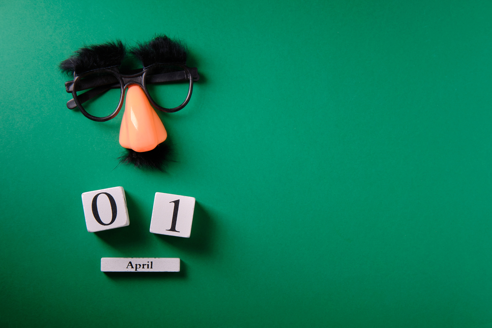 Fake mustache and glasses with blocks showing the date for April Fool's Day.