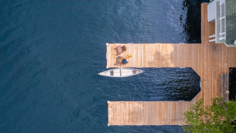 Aerial view of a cottage dock with a canoe.