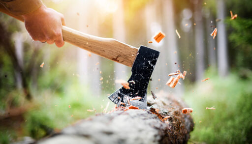 Close-up of an axe chopping wood.