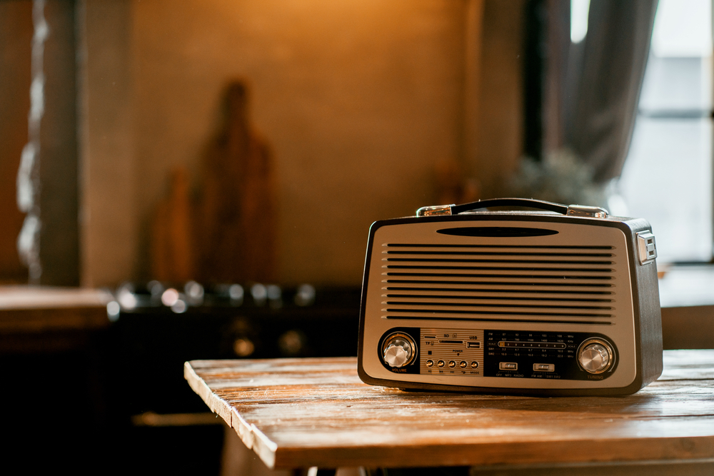 Close-up of an old radio receiver sitting on a wooden table.
