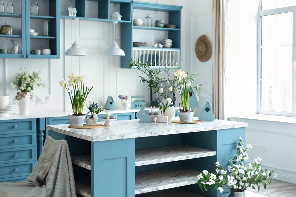 Cottage kitchen with blue cabinets and white, wood panelling.