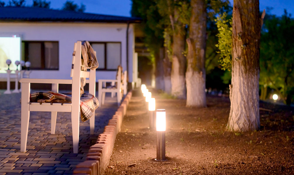 Row of exterior lights along a pathway in a yard.