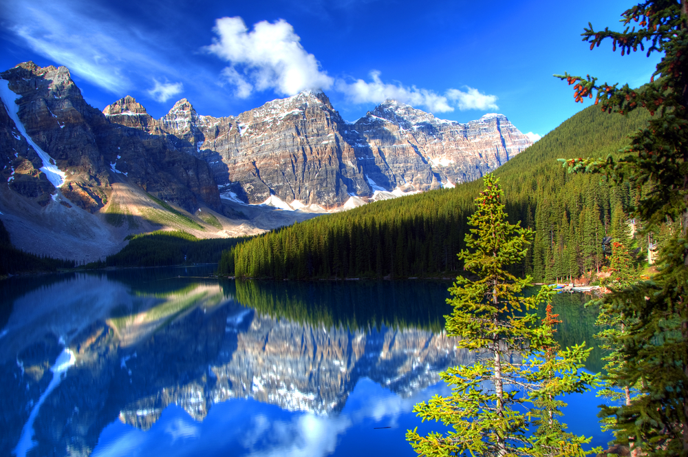 Reflections of mountains and trees in Moraine Lake, Alberta.