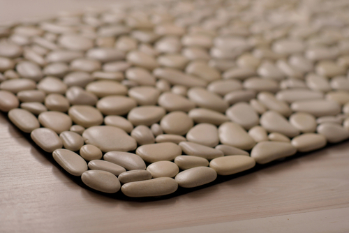 Close-up of a tan-coloured mat made of pebbles.