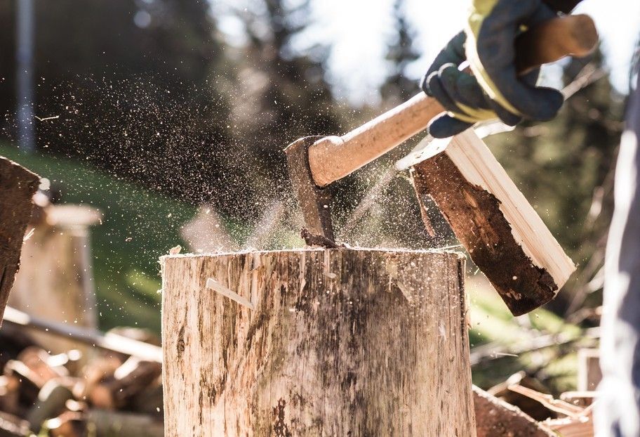 Close-up of an axe chopping a wood stump.