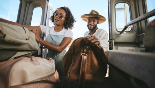 Man and woman packing luggage into a car.