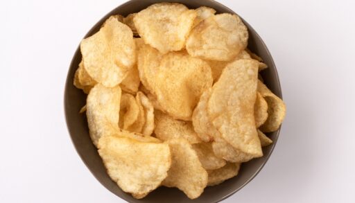 Overhead view of plain potato chips in a brown bowl.