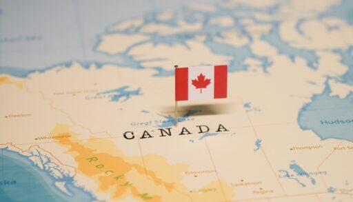 Close-up of a small Canadian flag on a map of Canada.