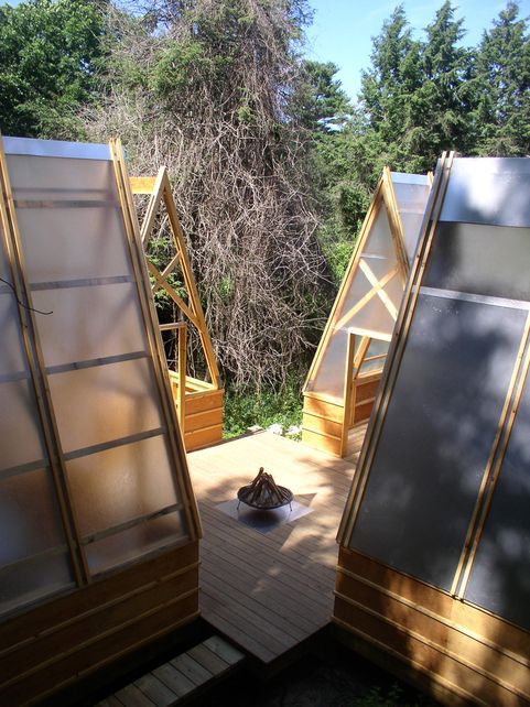 A day time shot of the fire pit and surrounding huts.
