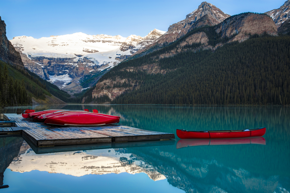 Row of red canoes on a turquoise lake in Banff National Park, Alberta.