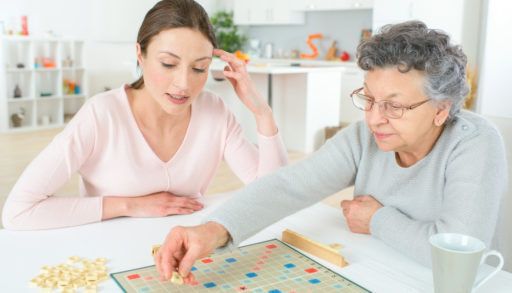 A young and an older women playing Scrabble.
