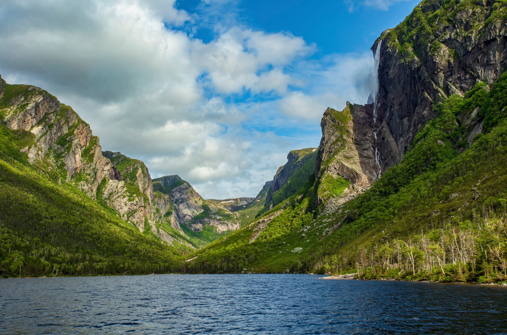 Grass-covered mountains surrounding Pissing Mare Falls in Gros-Morne National Park, Newfoundland.