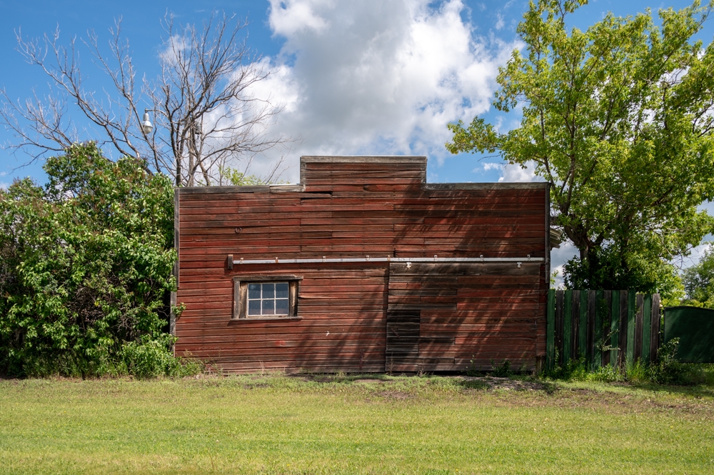 Old, abandoned red building in the ghost town of Fleet, Alberta.