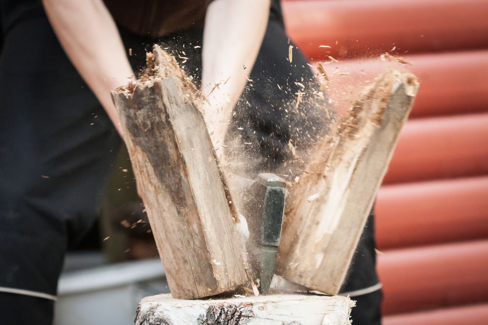 Close-up of a person splitting firewood.