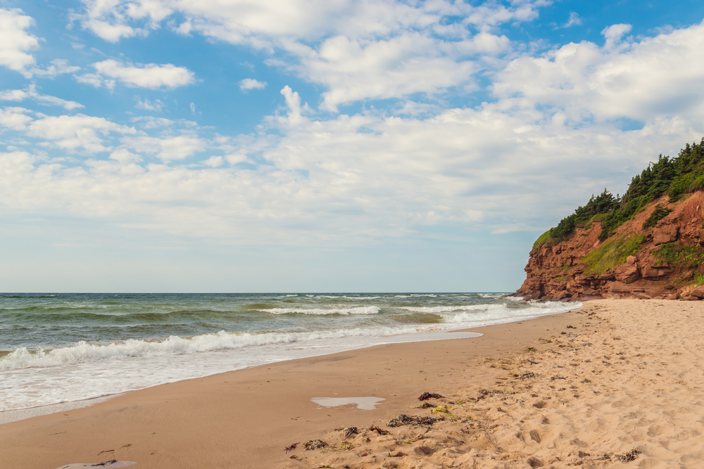 A beach with red cliffs at Basin Head, Prince Edward Island.