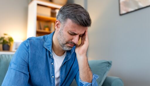 A man suffering from a headache holding his head.