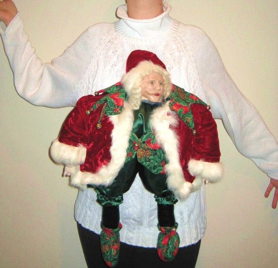 A sweater with a scary santa attached to the front