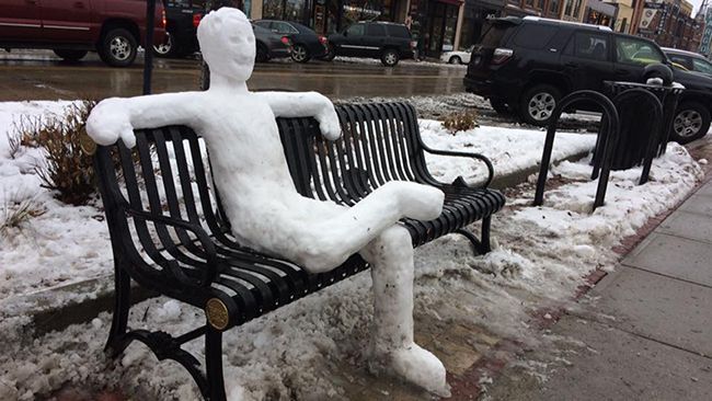 a snowman sitting on a bench
