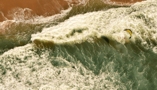 aerial photo of the beach and a windsurfer