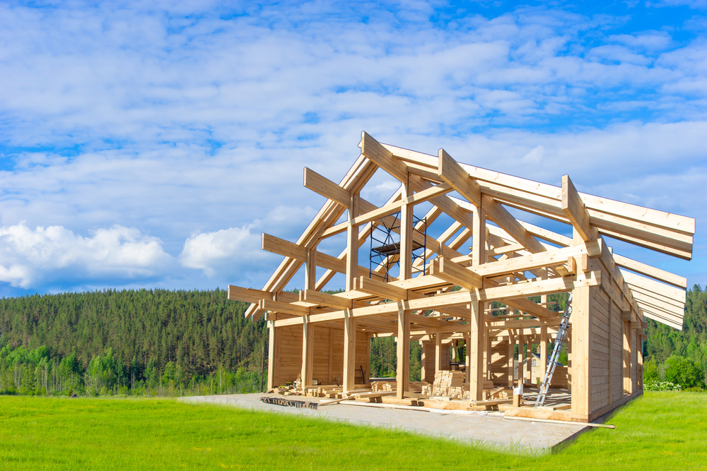 Framing of a house in a grassy field.