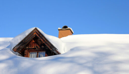 A snow-covered roof of a wooden house