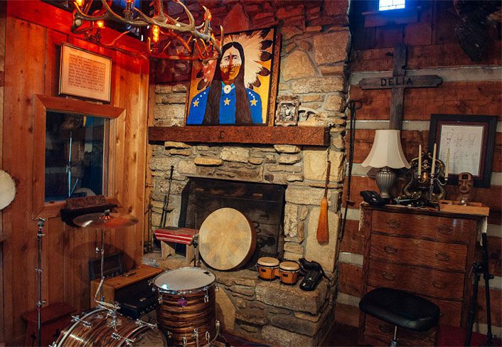 room with drums, lamps, and stone fireplace
