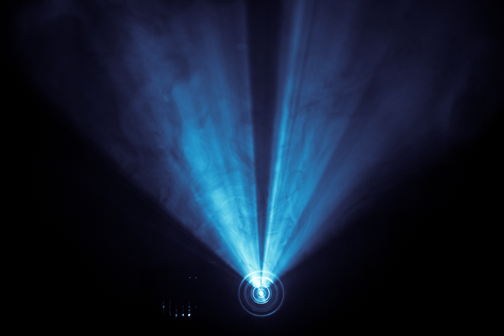 Movie projector creating blue light in a dark room.