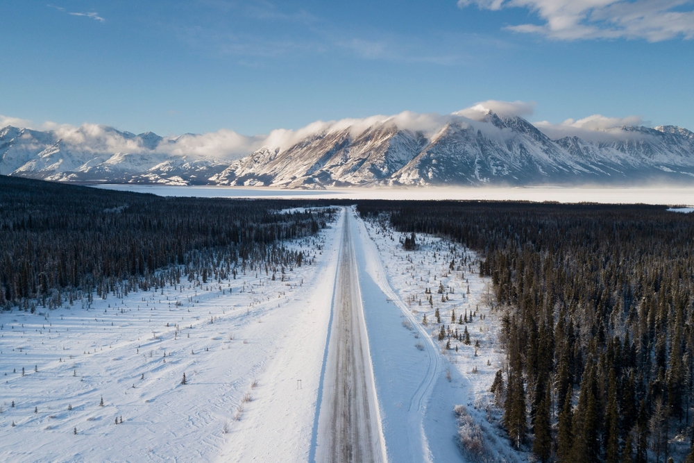 Ariel view of mountain and tree landscape with a road in the middle in Whitehorse, Yukon, Canada.
