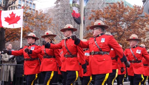 Canadian mounties in signature red uniform marching down a street in Ottawa.