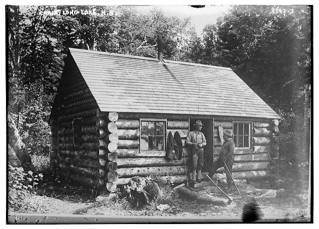 Two men in front of log cabin