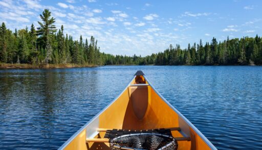 Point of view from inside a yellow canoe on the water.