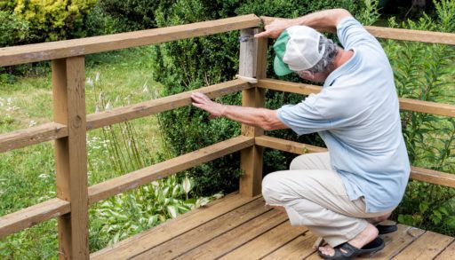 An older man working on a deck.