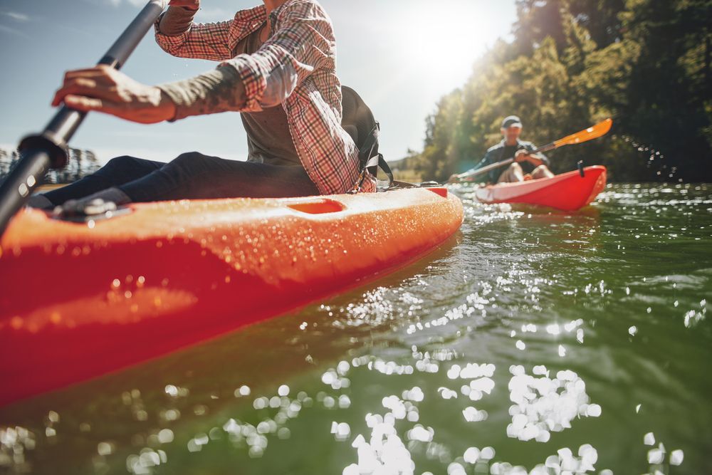 Close-up of two people canoeing on a sunny lake.
