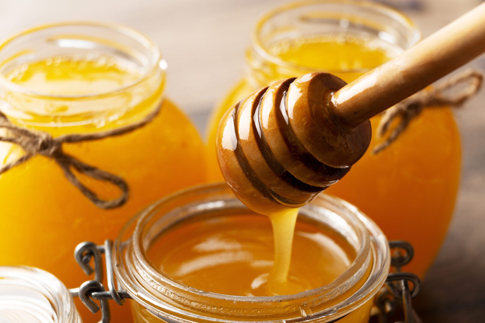 Honey on wooden honey-dipper, close up