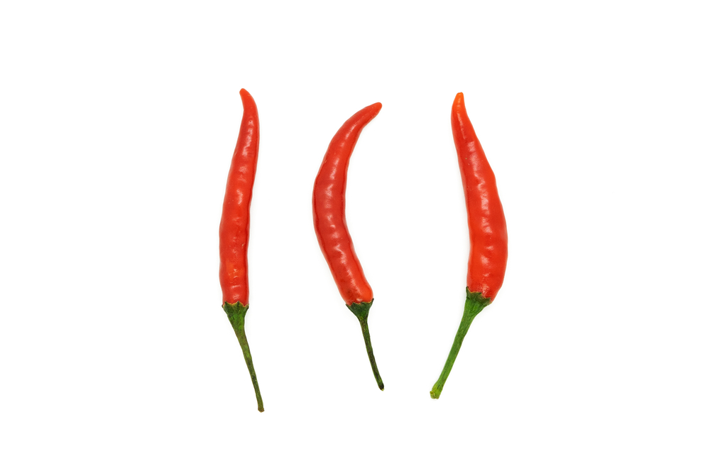 Three red chili peppers isolated on a white background.