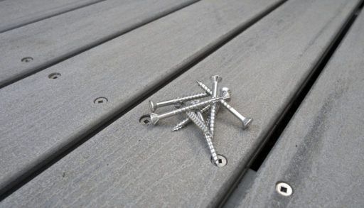 Pile of nails sitting on a grey deck.